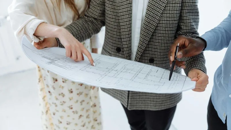 Whiteboard listing action items with owner names and dates